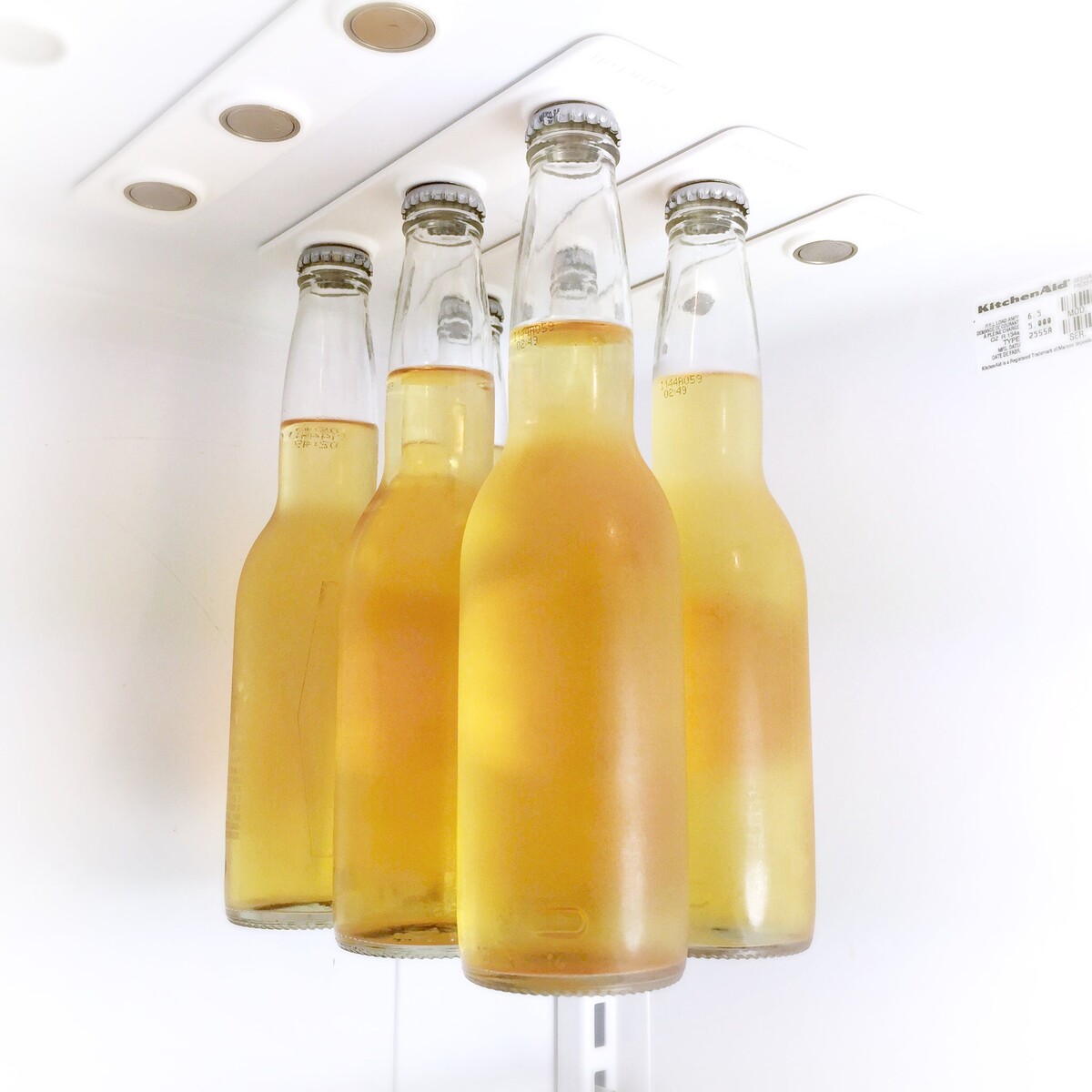 多只饮料瓶通过BottleLoft悬挂在冰箱顶板下